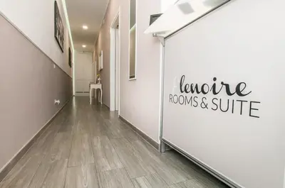 a hallway with a white wall with a sign that reads lecture rooms and suite at Elenoire Rooms & Suite in Rome