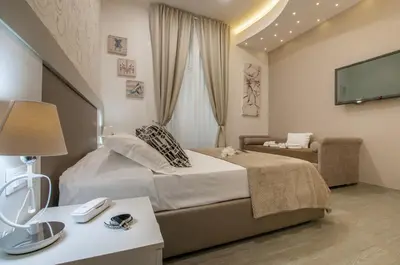 a bedroom with a bed and a couch and a television at Elenoire Rooms & Suite in Rome