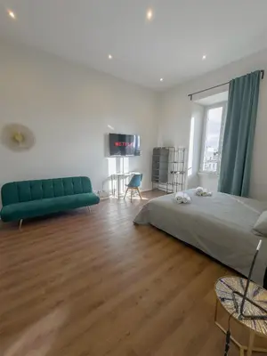 a bedroom with a bed and a green couch at Colosseum Charme in Rome