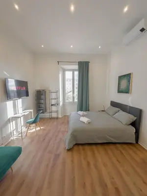a bedroom with a bed and a living room with a table at Colosseum Charme in Rome