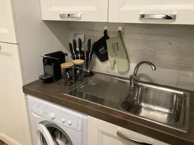 a kitchen with a sink and a washing machine at Trastevere Home Garibaldi 14 in Rome