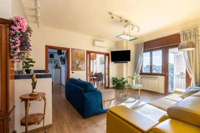 a living room with a blue couch and a tv at Roots of Rome Apartment in Rome