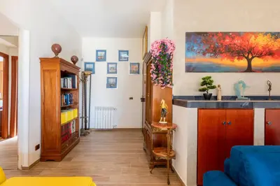 a living room with a blue couch and a painting on the wall at Roots of Rome Apartment in Rome