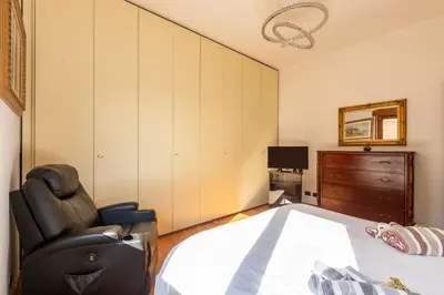 a bedroom with a bed and a chair and a television at Roots of Rome Apartment in Rome