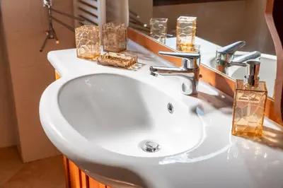 a white bathroom sink with candles on it at Roots of Rome Apartment in Rome