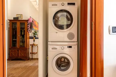 a washing machine and a dryer in a hallway at Roots of Rome Apartment in Rome