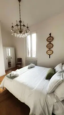 a large white bed in a room with a chandelier at Dome View in Rome