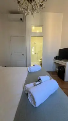 a large white bedroom with two beds with towels at Dome View in Rome