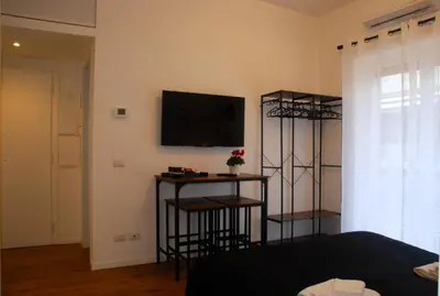 a room with a bed and a television on a wall at Viva la vida in Rome in Rome