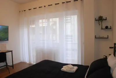a bedroom with a large window with white curtains at Viva la vida in Rome in Rome