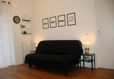 a black chair in a room with a clock on the wall at Viva la vida in Rome in Rome