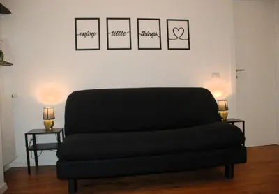a black couch in a room with three pictures on the wall at Viva la vida in Rome in Rome