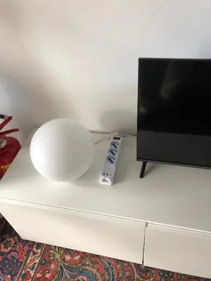 a remote control sitting on a white table next to a tv at Apartment in green oasis in Rome