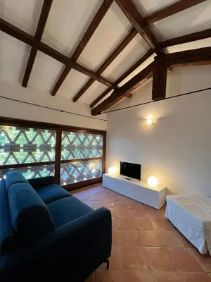 a living room with a blue couch and a tv at Apartment in green oasis in Rome