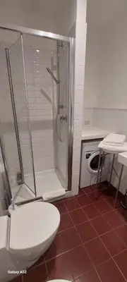 a bathroom with a shower and a toilet and a washing machine at Bijoux de Rome Campo dei Fiori Apart in Rome