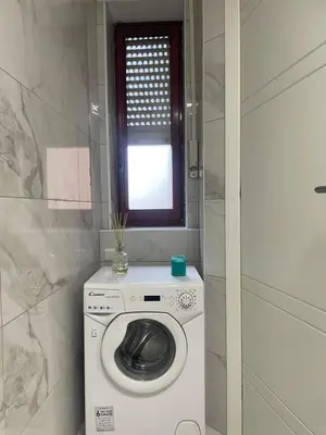 a washing machine in a bathroom with a window at Dama Maria Elena - 1 min walk to Valle Aurelia Metro in Rome