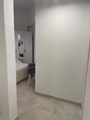 a room with a white wall and a bedroom at Dama Maria Elena - 1 min walk to Valle Aurelia Metro in Rome