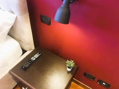 a table with a remote control and a lamp on it at Urbanhome, ready to visit Rome! in Rome