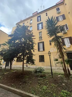 a large building with two trees in front of it at Guest House David San Lorenzo in Rome
