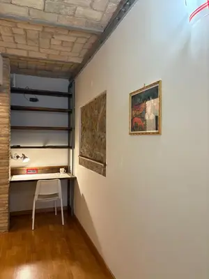 a room with a table and paintings on the wall at Guest House David San Lorenzo in Rome