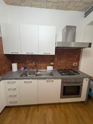 a kitchen with white cabinets and a sink at Guest House David San Lorenzo in Rome