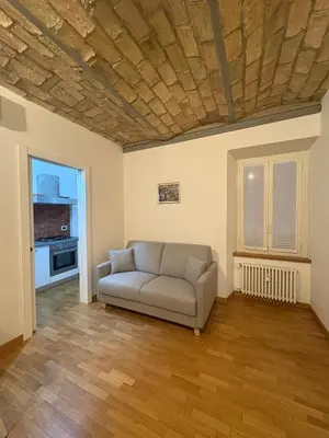 a couch in a living room with a wooden ceiling at Guest House David San Lorenzo in Rome