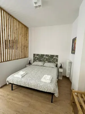 a bedroom with a bed in a white room at Charming House Tuscolana - Roma in Rome