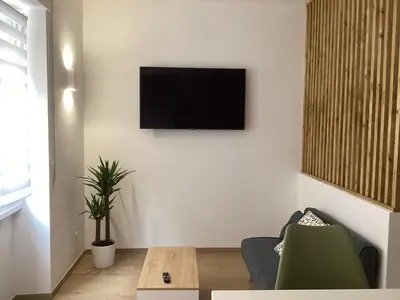 a living room with a television on a white wall at Charming House Tuscolana - Roma in Rome