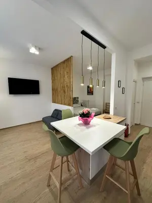 a kitchen and living room with a white table and chairs at Charming House Tuscolana - Roma in Rome