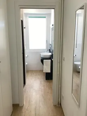 a bathroom with a window and a sink and a mirror at Charming House Tuscolana - Roma in Rome