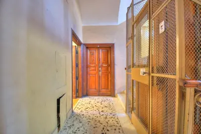 a hallway with a wooden door and a tile floor at Via Veneto Cosy House in Rome