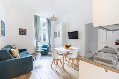 a kitchen and living room with a couch and a table at Hostly-The Porta Pia Suite-Rome Centre with Charme in Rome