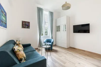 a living room with a blue couch and a tv at Hostly-The Porta Pia Suite-Rome Centre with Charme in Rome