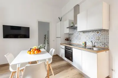 a kitchen and dining room with a white table and chairs at Hostly-The Porta Pia Suite-Rome Centre with Charme in Rome