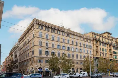 a large building with cars parked in front of it at Hostly-The Porta Pia Suite-Rome Centre with Charme in Rome