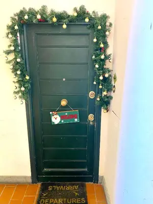 a green door with christmas wreaths on it at Scent Of Trastevere in Rome