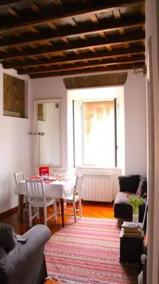 a living room with a table and a dining room at Scent Of Trastevere in Rome