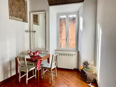 a dining room with a table and chairs and a window at Scent Of Trastevere in Rome
