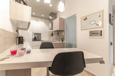 a kitchen with a desk and chairs in a room at Il Nido di Roma - Ospedale Gemelli & Garden in Rome