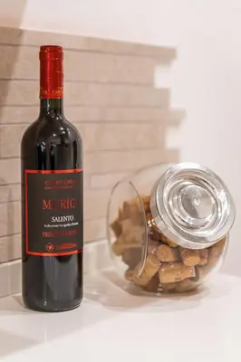 a bottle of wine next to a container of nuts at Il Nido di Roma - Ospedale Gemelli & Garden in Rome