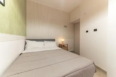 a bedroom with a large white bed in a room at Il Nido di Roma - Ospedale Gemelli & Garden in Rome