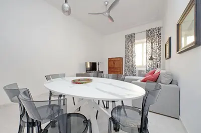 a dining room with a white table and chairs at New Comfortable 2 Br Della Vittoria by Halldis in Rome