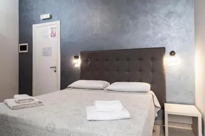 a bedroom with a bed with two towels on it at Ricky Home in Rome