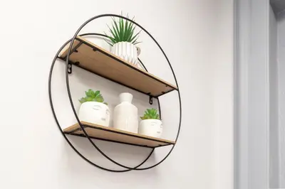 a round mirror hanging on a wall with plants at Ricky Home in Rome