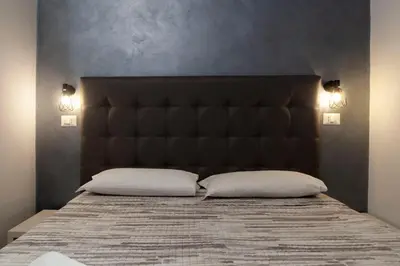 a bedroom with a large bed with two pillows at Ricky Home in Rome