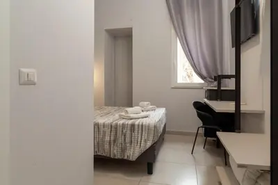 a bedroom with a bed and a desk and a window at Ricky Home in Rome