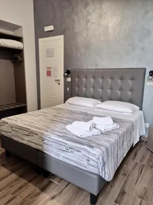 a bedroom with a bed with two towels on it at Ricky Home in Rome