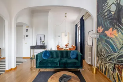 a living room with a green couch and a painting at Elegant Penthouse with Terrace in Rome