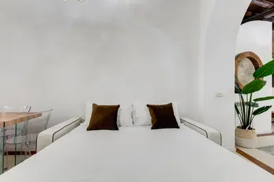 a white bed with pillows in a white room at NEW ROMAN Apartment - Rome Dream Home in Rome