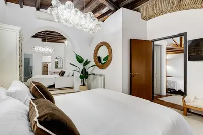 a bedroom with a white bed and a chandelier at NEW ROMAN Apartment - Rome Dream Home in Rome